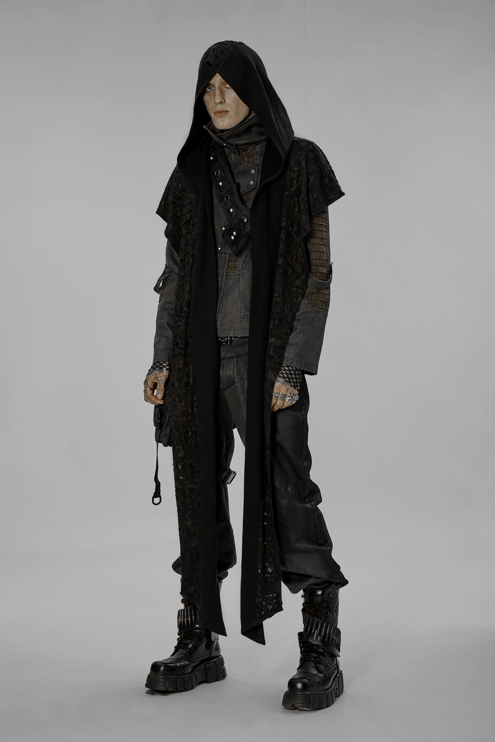 Male model wearing a deconstructed knit hooded cape, distressed knit fabric, and edgy style boots.