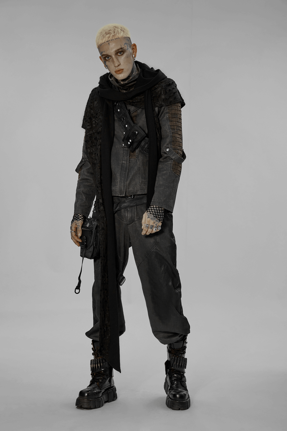 Edgy male model in distressed knit hooded cape with long scarf, showcasing a dark, post-apocalyptic style.