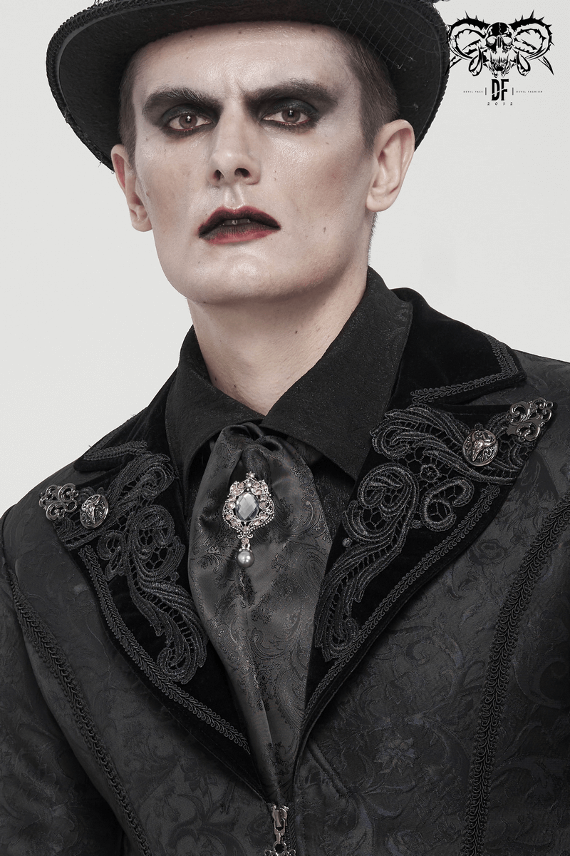 Male model in gothic attire featuring a black floral printed tie with a crystal brooch, showcasing vintage style.