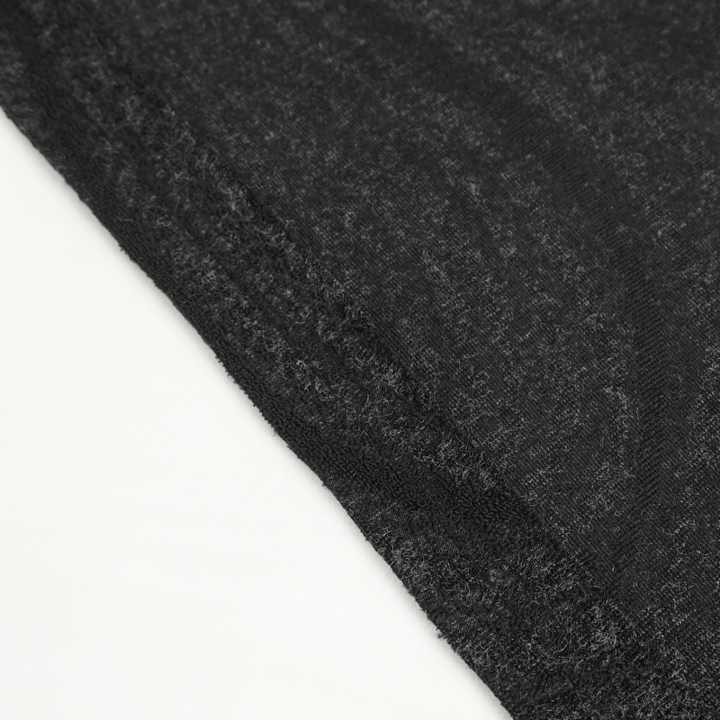 Close-up of the dark fabric texture of a male gothic irregular hooded coat.