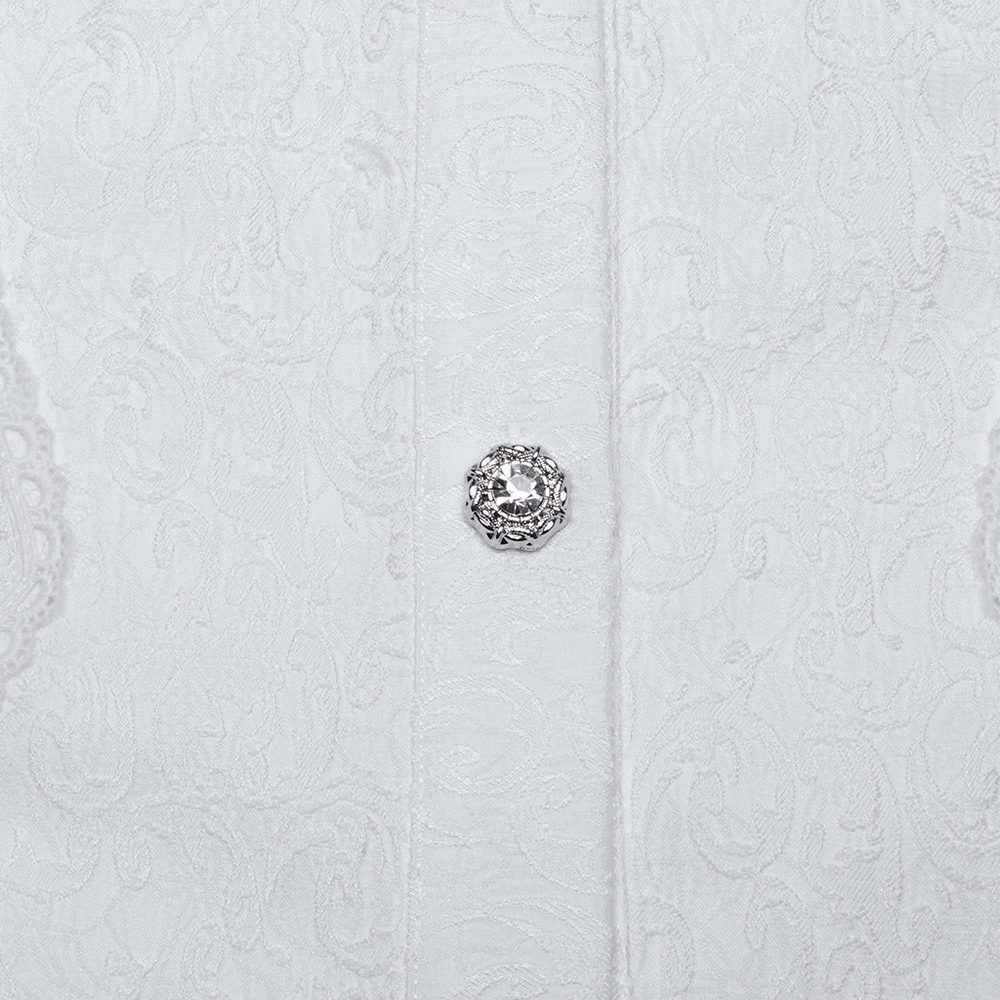 Close-up of a silver ornate button on a textured white fabric, enhancing gothic elegance and intricate detailing.