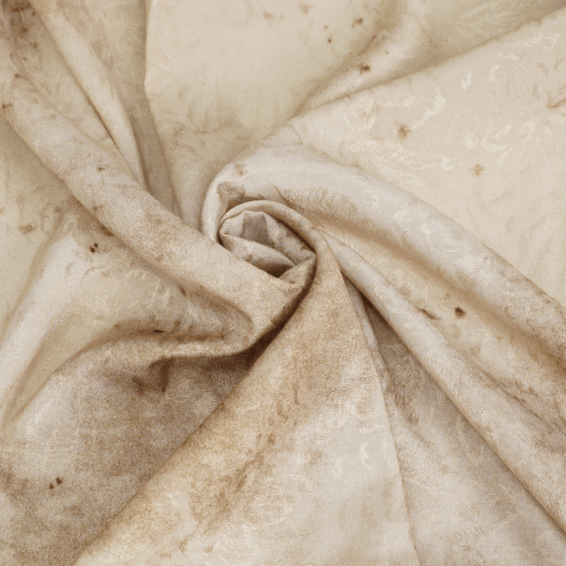 Close-up of luxurious distressed fabric with elegant patterns in soft beige and brown tones.