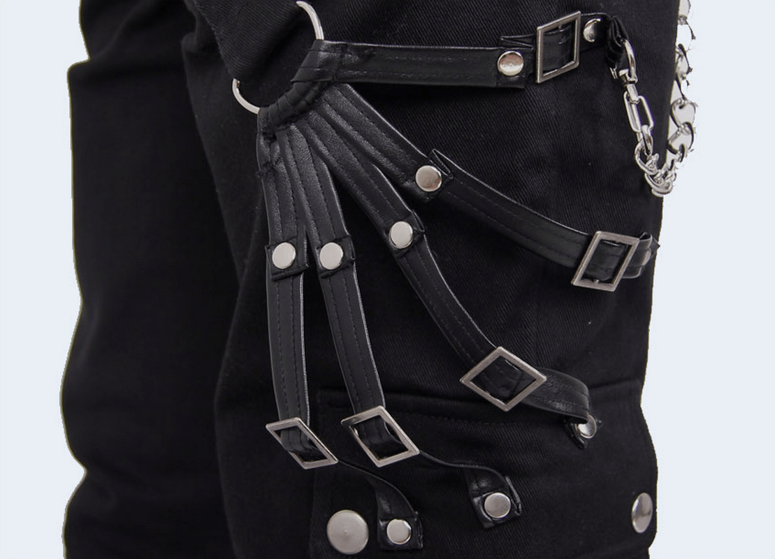 Close-up of punk rock men's pants featuring decorative straps and silver chain for a stylish, edgy look.