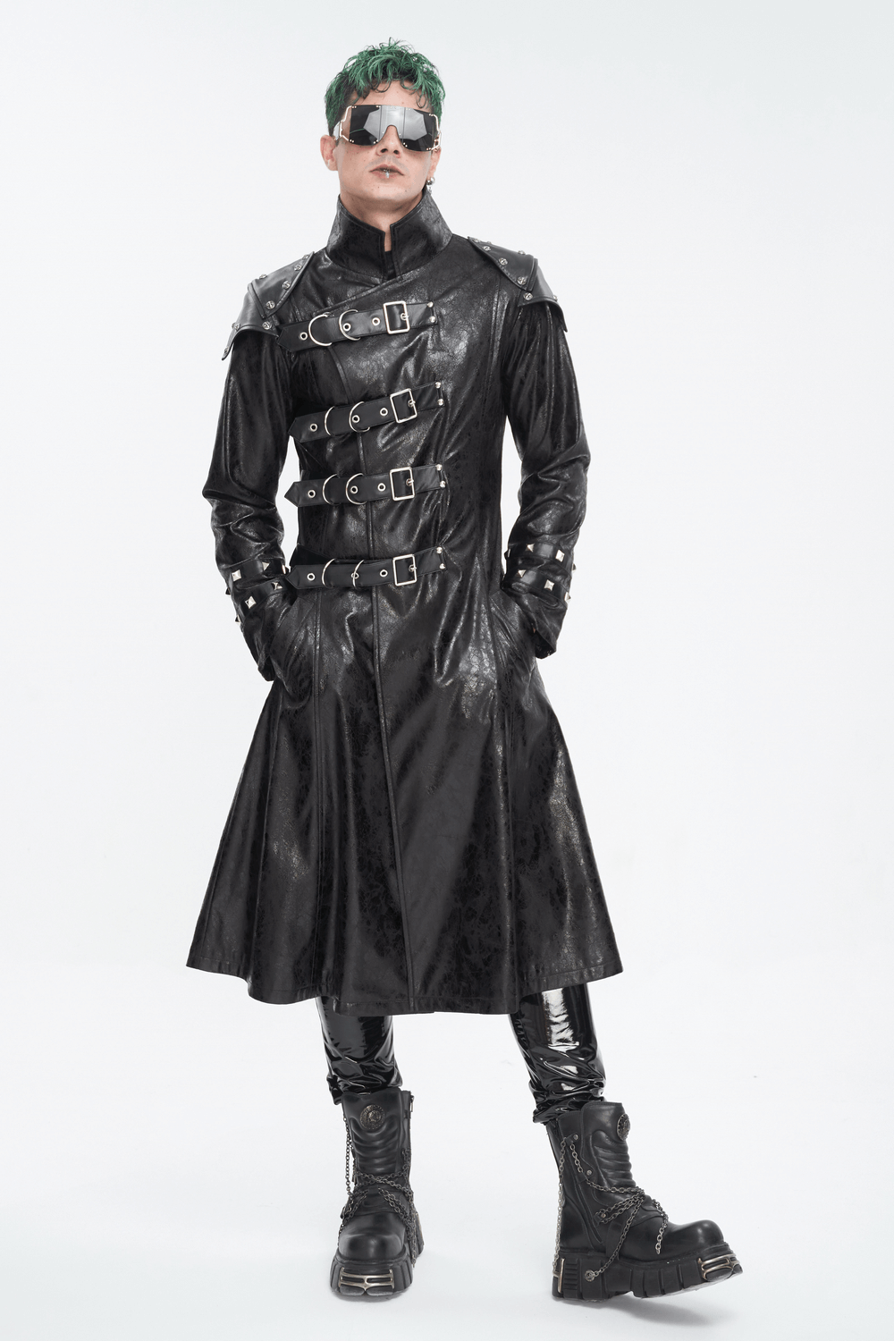 Male model in a black punk faux leather coat with stand collar and bold buckles, showcasing a rebellious style.