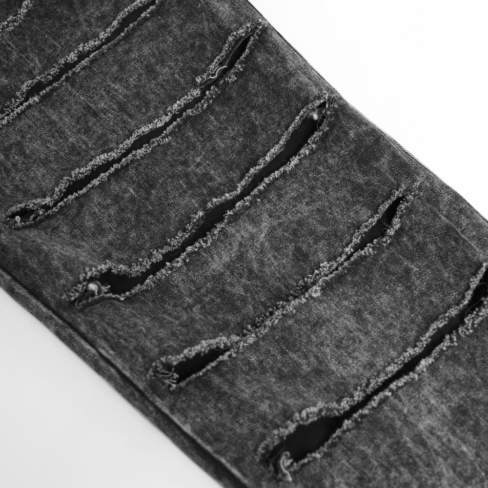 Distressed black denim pants with extreme shredded leg slashes and raw-edge details for a grunge gothic look.