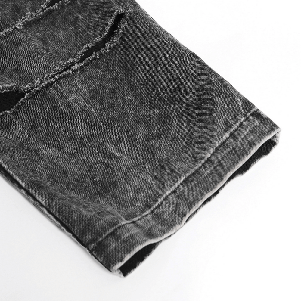 Close-up of ripped black denim pants showcasing distressed edges and frayed details in a gothic style.