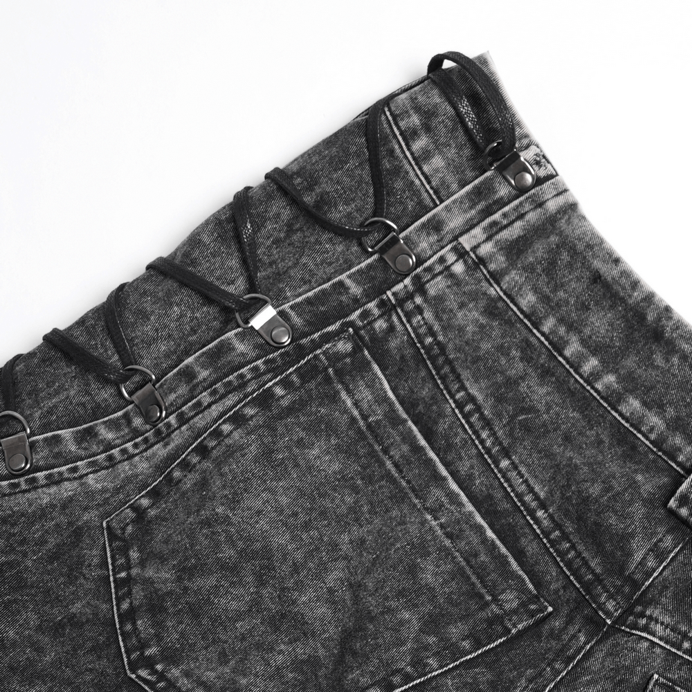 Close-up of male ripped grunge pants with lace-up sides and distressed black denim for a gothic edgy style.