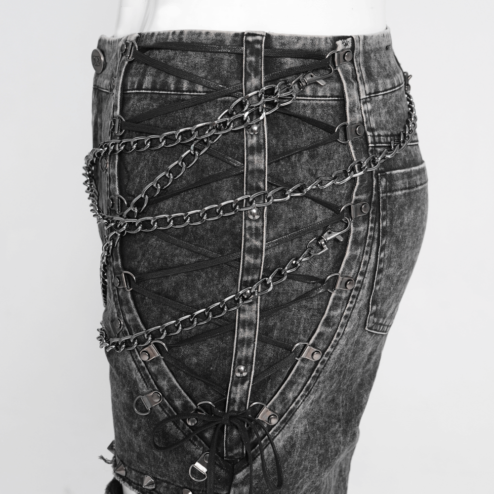 Male ripped pants showcasing layered chains and lace-up details for a grunge gothic style.