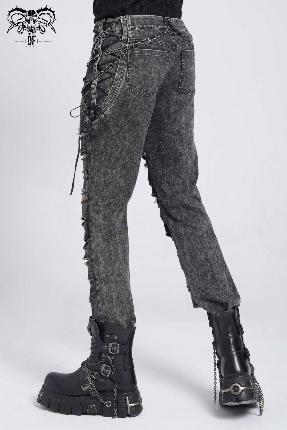 Gothic ripped denim pants with chains, lace-up sides, and edgy detail, paired with chunky platform boots.