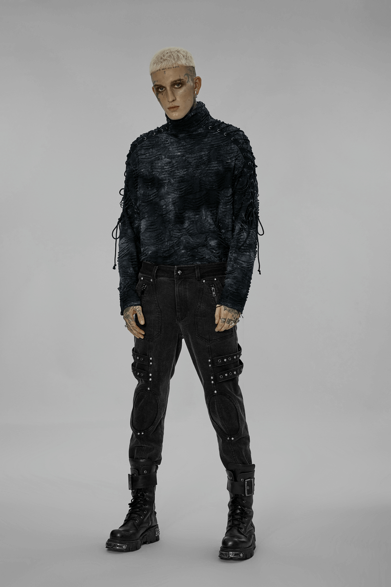 Fashion-forward male model in black rugged denim cargo pants with edgy knee patches and a stylish dark top.