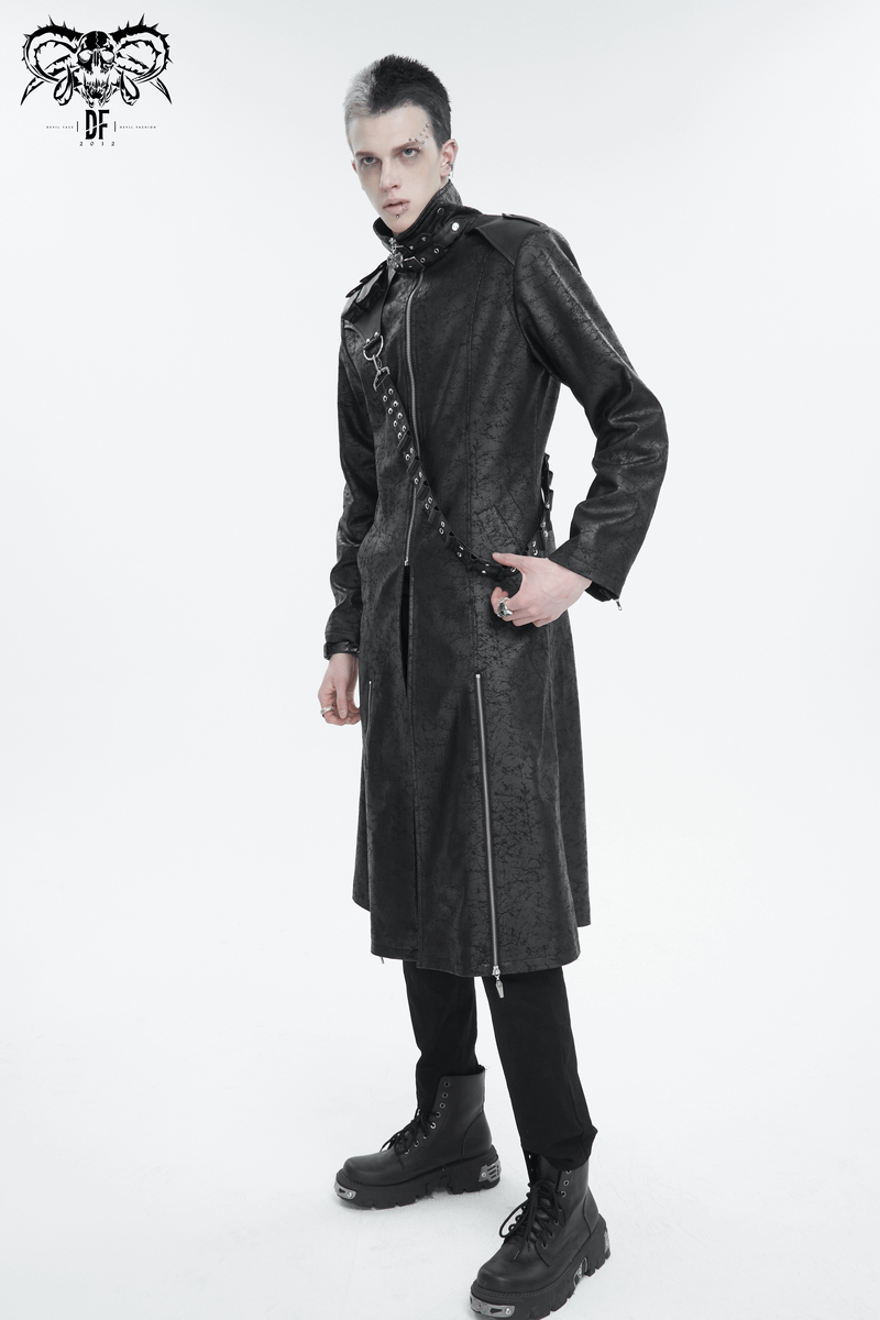 Stylish male model in a long black stand collar coat with a detachable strap and edgy boots.