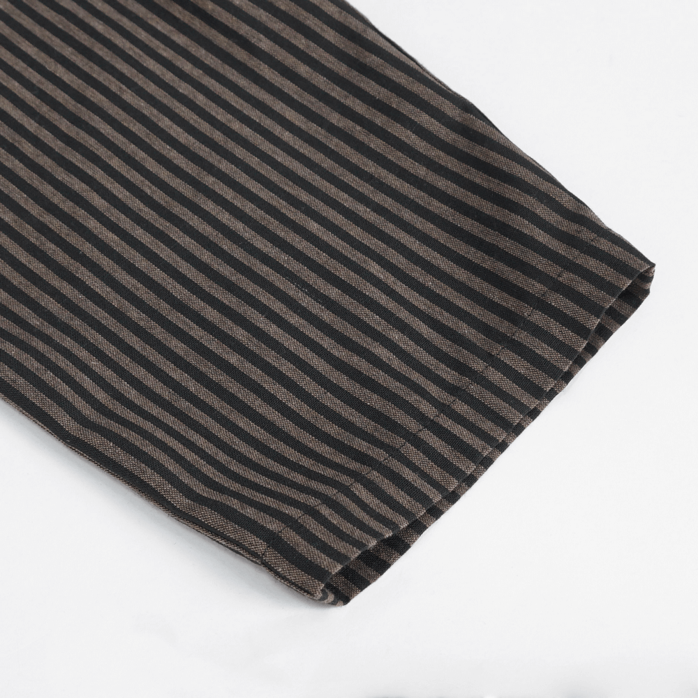 Close-up of male high-waist trousers showcasing elegant black and brown striped fabric with a sleek hemline.
