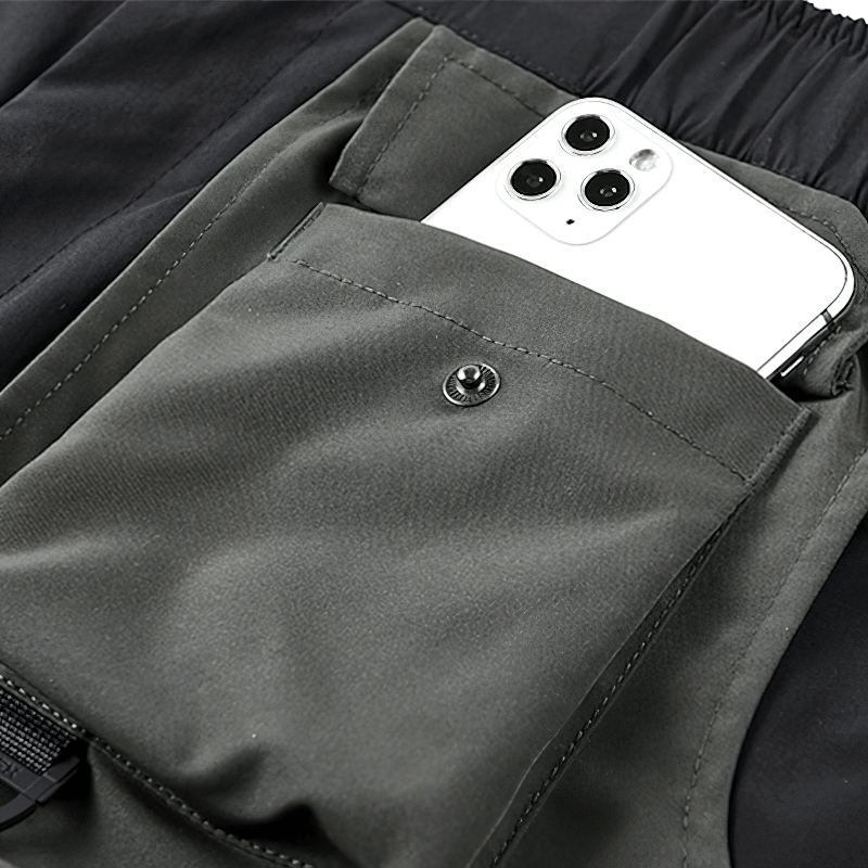 Close-up of tactical shorts pocket with smartphone, showcasing functionality and style in alternative fashion.