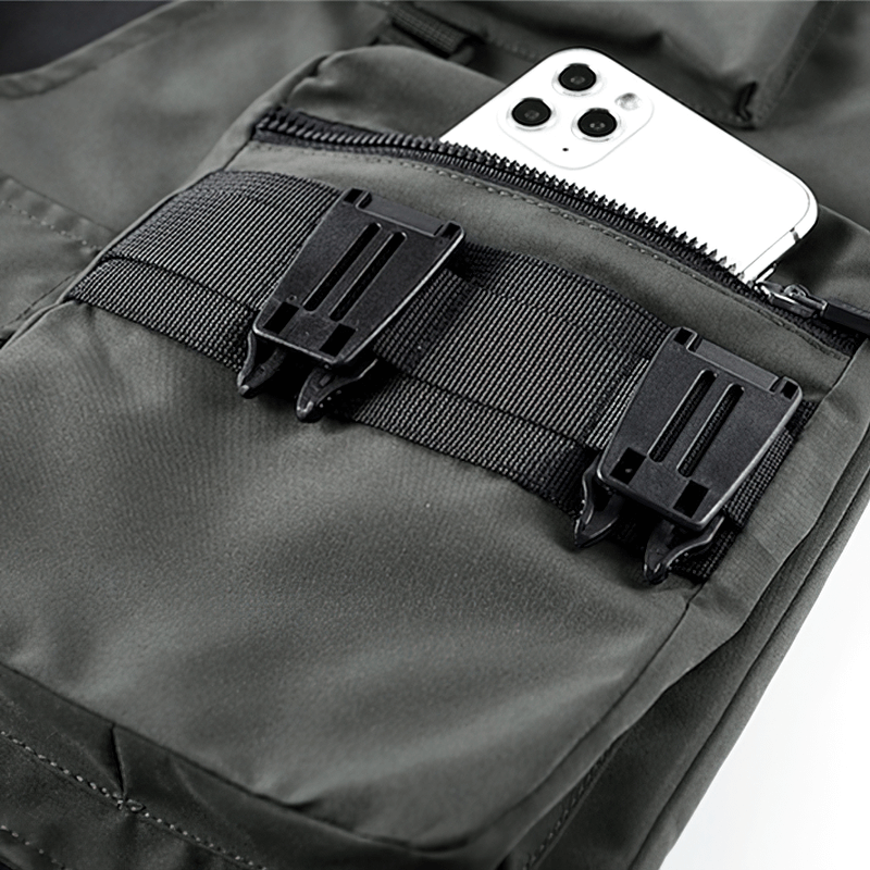 Close-up of tactical shorts pocket with phone and buckles, showcasing functionality and style in urban fashion.