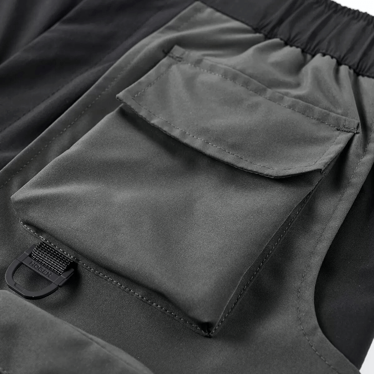Detailed view of tactical multi-pocket shorts showcasing stylish patchwork and practical side pocket.