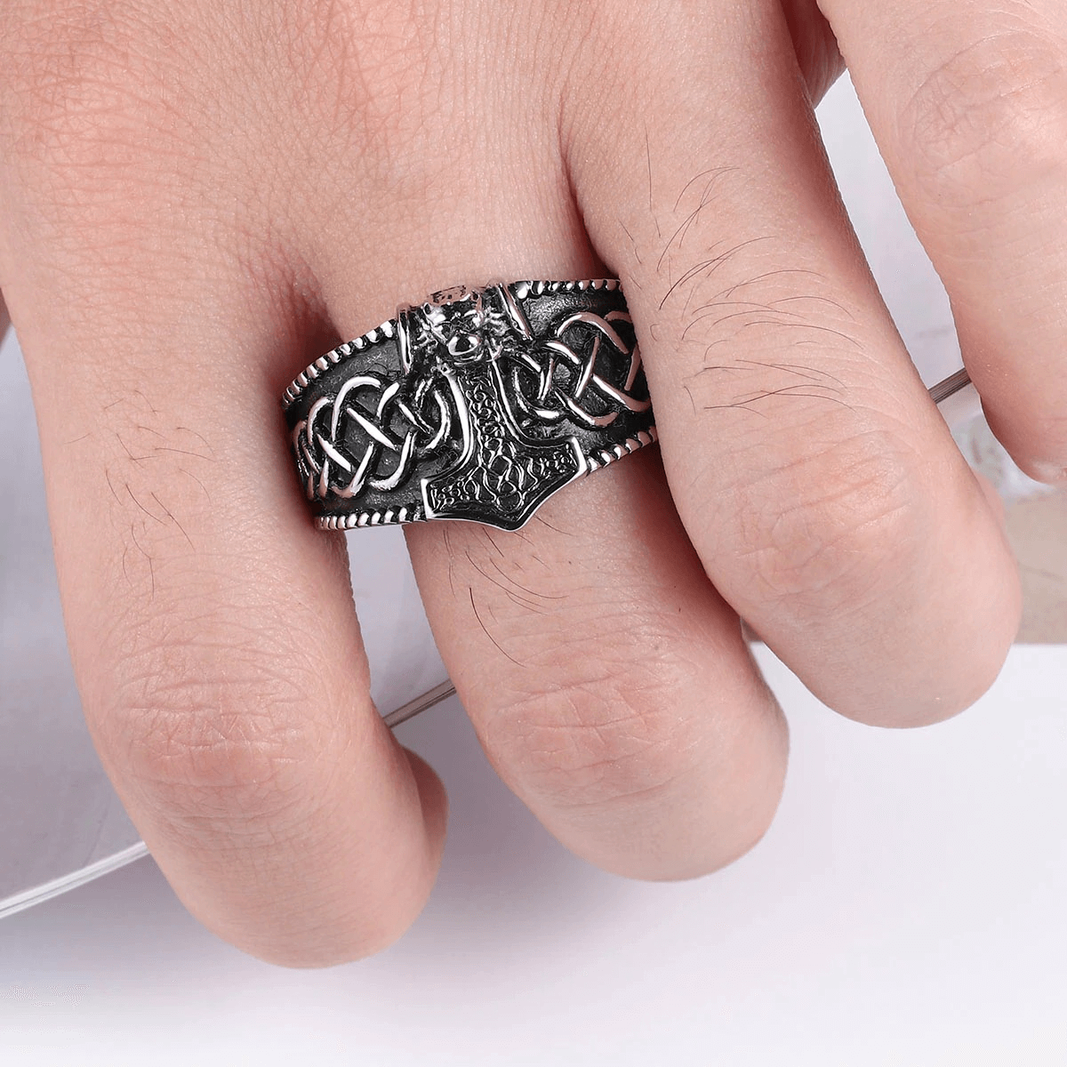Men's vintage Celtic Thor's Hammer ring on a hand, featuring intricate punk style patterns in stainless steel.