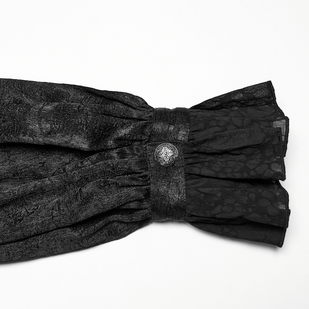 Close-up of the ruffled cuff on a male Victorian black shirt featuring lace and an engraved button.
