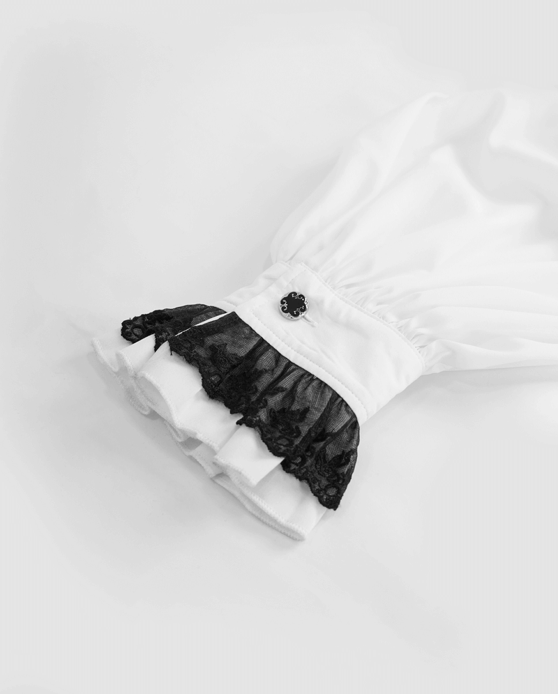 Close-up of gothic style white shirt cuff with black lace trim and decorative button.