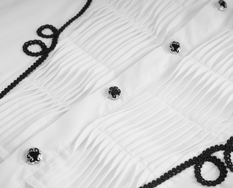 Close-up of vintage men's white gothic shirt with lace details on collar and cuffs, showcasing stylish black accents and pleats.