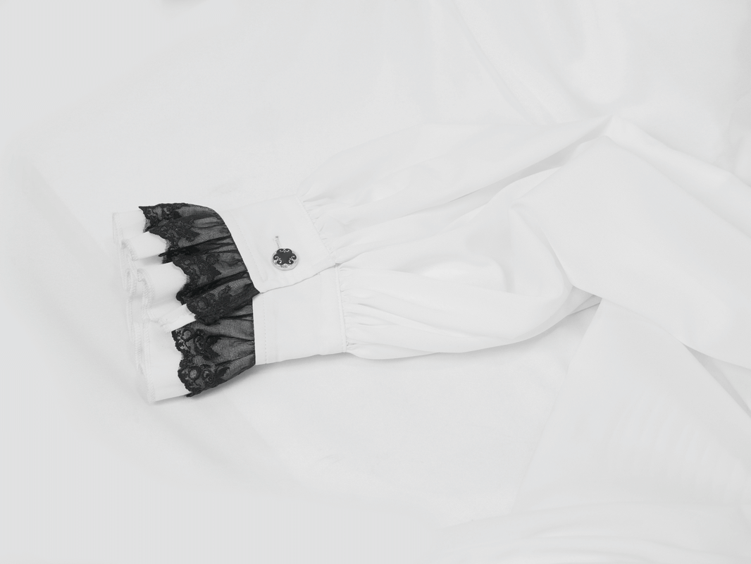 Close-up of a white vintage men's shirt cuff with black lace detailing, showcasing gothic style elegance.