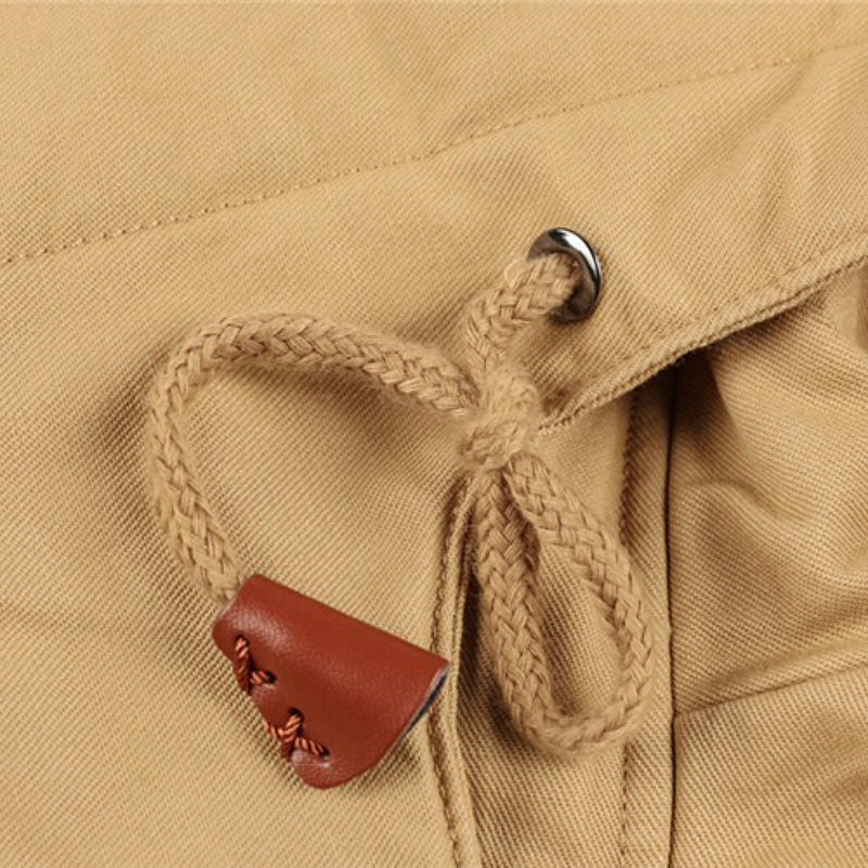 Close-up of the beige drawstring toggle on a male winter fleece jacket, showcasing stylish and functional design.