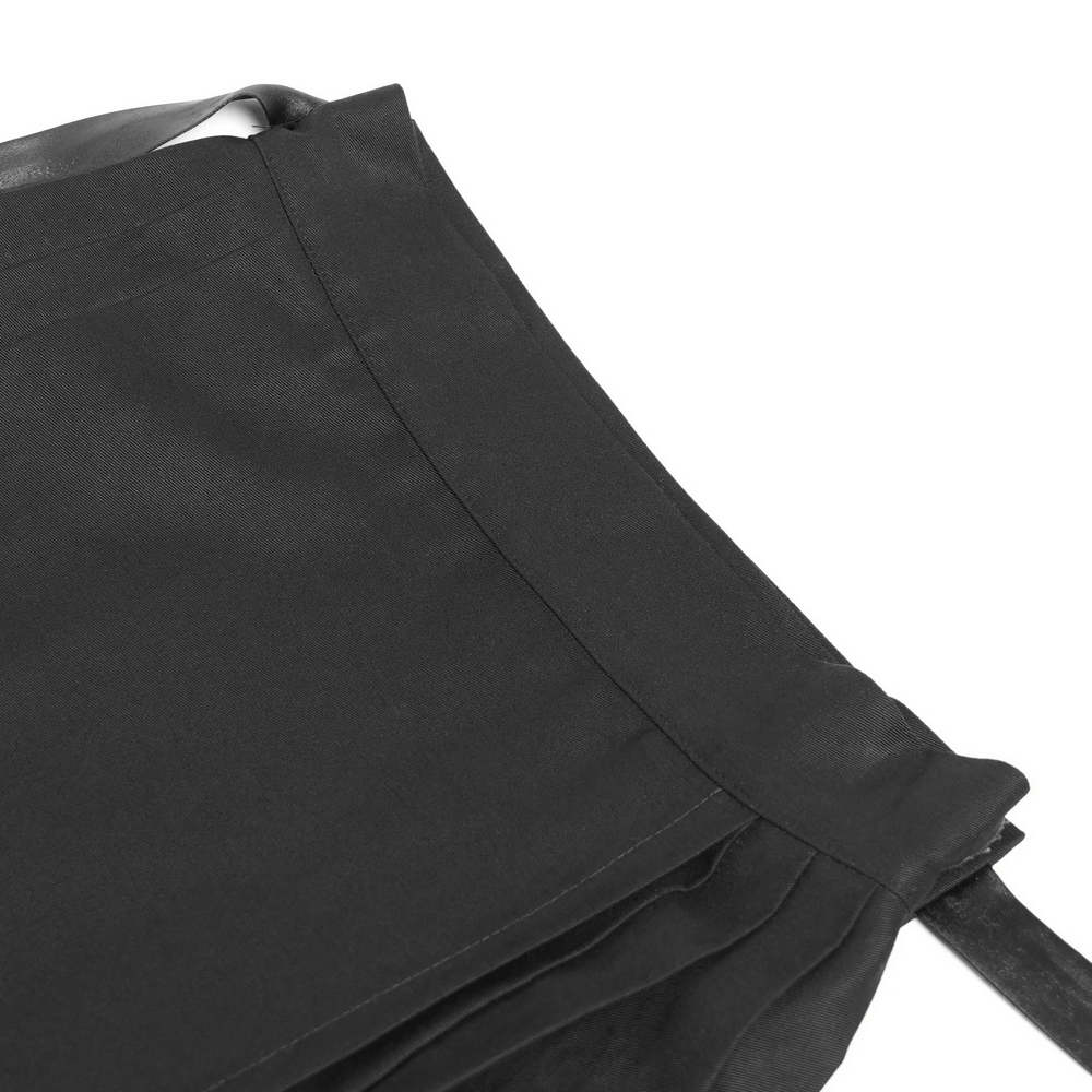 Close-up of a black maxi skirt showcasing pentagram straps and grommet details, perfect for edgy fashion lovers.