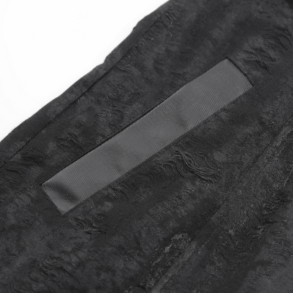 Close-up of the textured fabric and pocket detail on a men's gothic hooded coat.