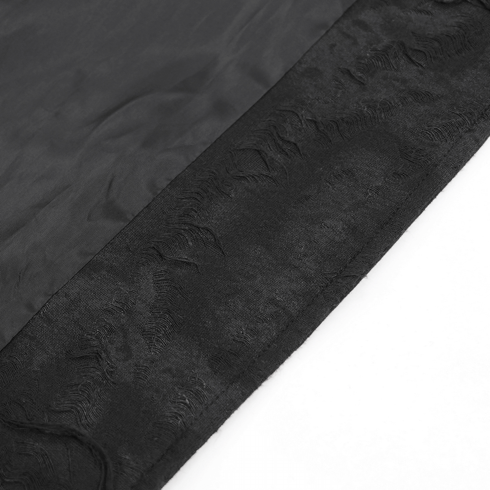 Close-up of textured black fabric showcasing intricate design for a gothic hooded coat.