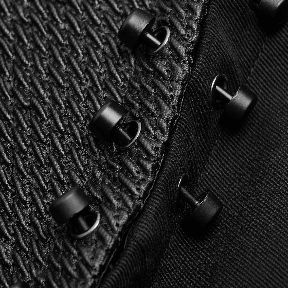 Close-up of black fabric and stylish metal buttons on a gothic long coat, showcasing unique texture and detail.