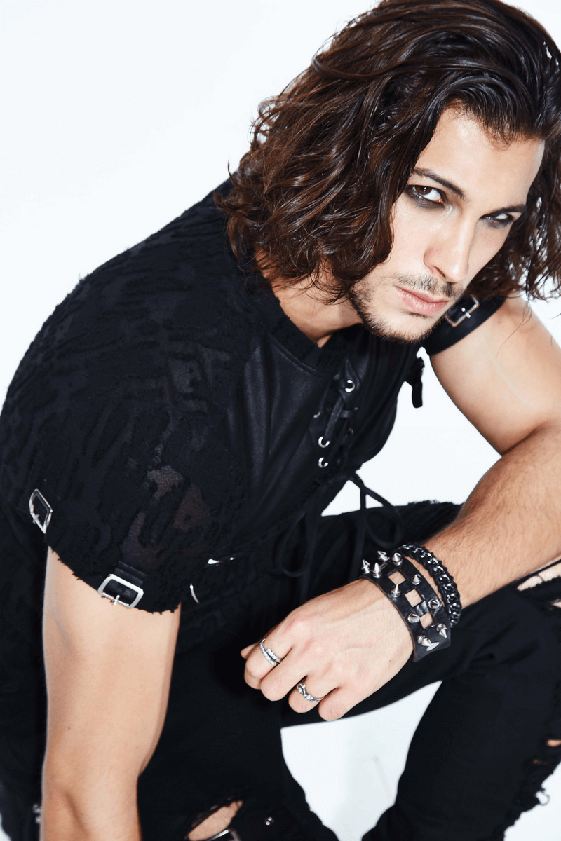 Stylish man in black detachable sleeves top with leather overlay, showcasing gothic fashion and alternative clothing.