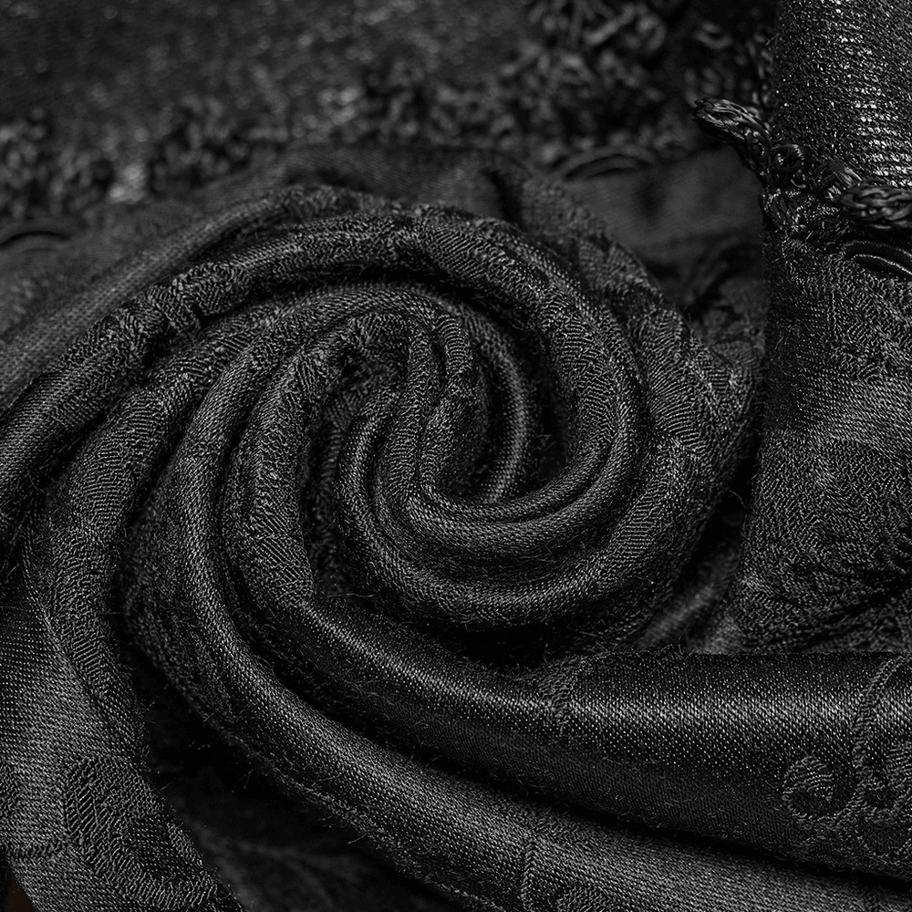 Close-up of luxurious black jacquard fabric, showcasing elegant lace detailing and intricate texture.