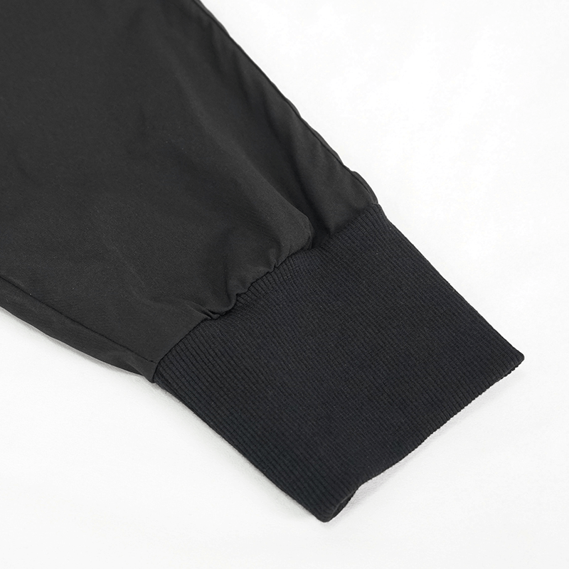 Close-up of black punk cargo trousers' cuff, showcasing elastic waistband for comfort and style.