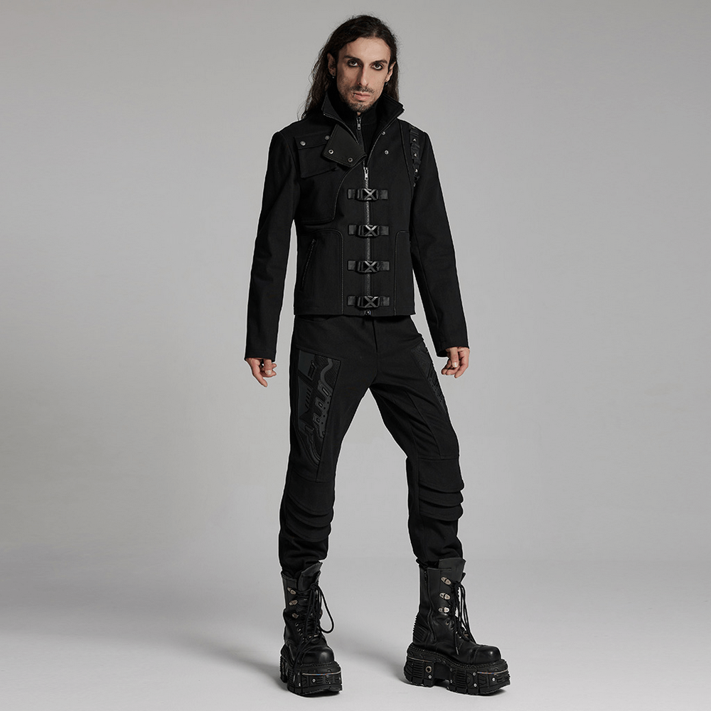 Stylish man in black cyberpunk jacket with buckles, rivet details, and zippered pockets, paired with combat boots.