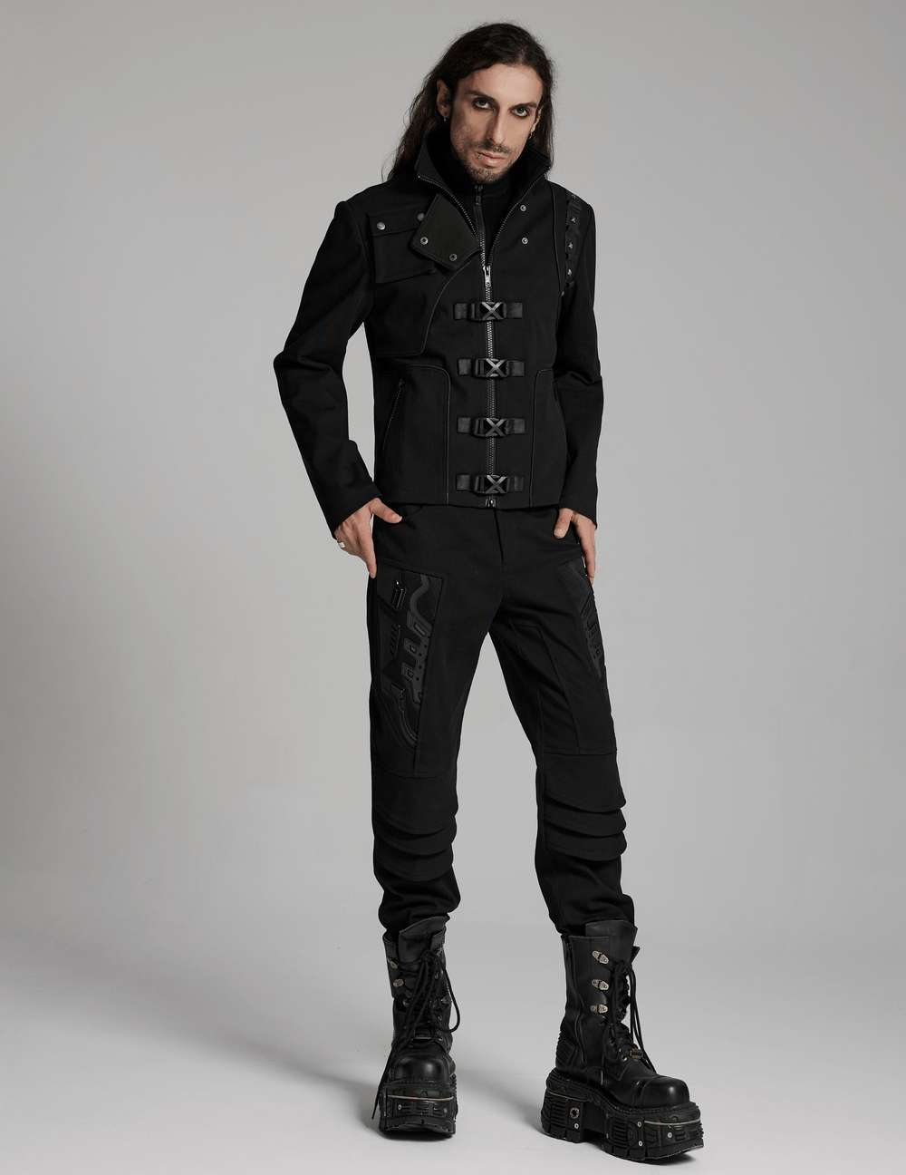 Men's cyberpunk jacket with buckles, rivets, and zippered pockets, styled with black combat boots.