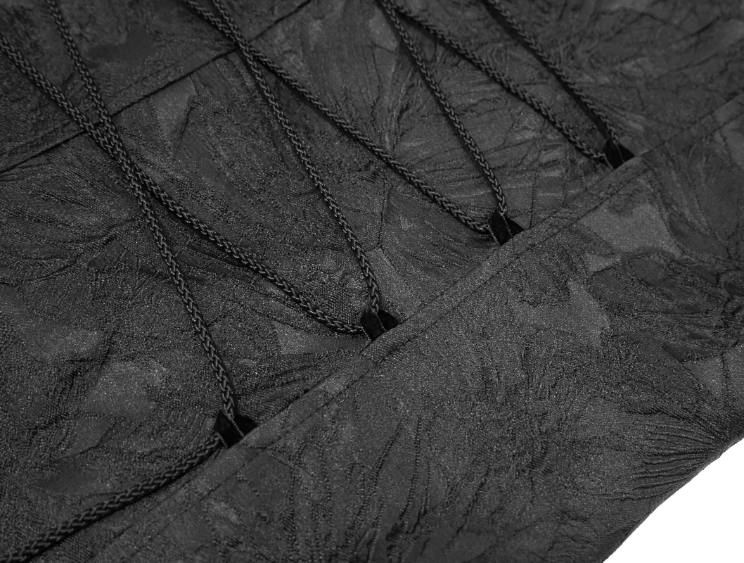 Close-up of elegant lacing detail on a black gothic jacket, showcasing vintage fabric texture.