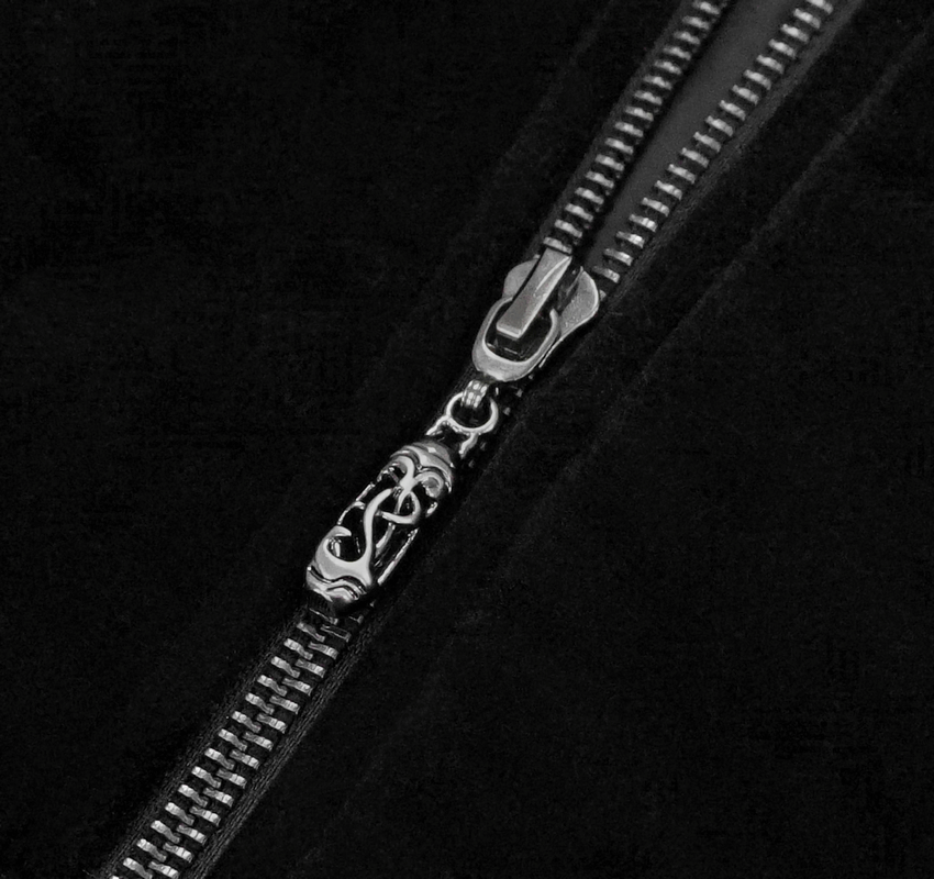 Close-up of a gothic-style black jacket zipper featuring intricate detailing for a vintage look.