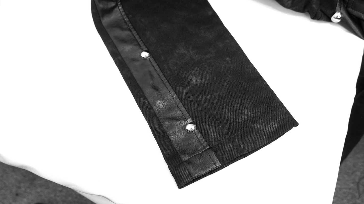 Close-up of black faux leather zipper trousers featuring silver metal rivets and stylish design for punk fashion.