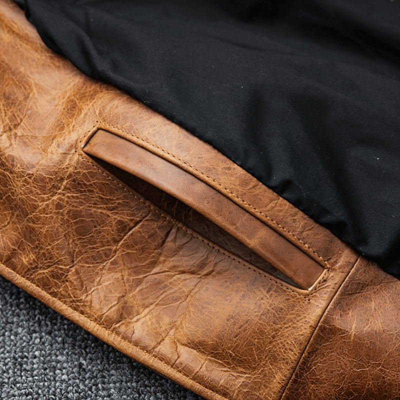 Close-up of the durable brown leather patch on a men's motorcycle jacket, showcasing its retro casual style.