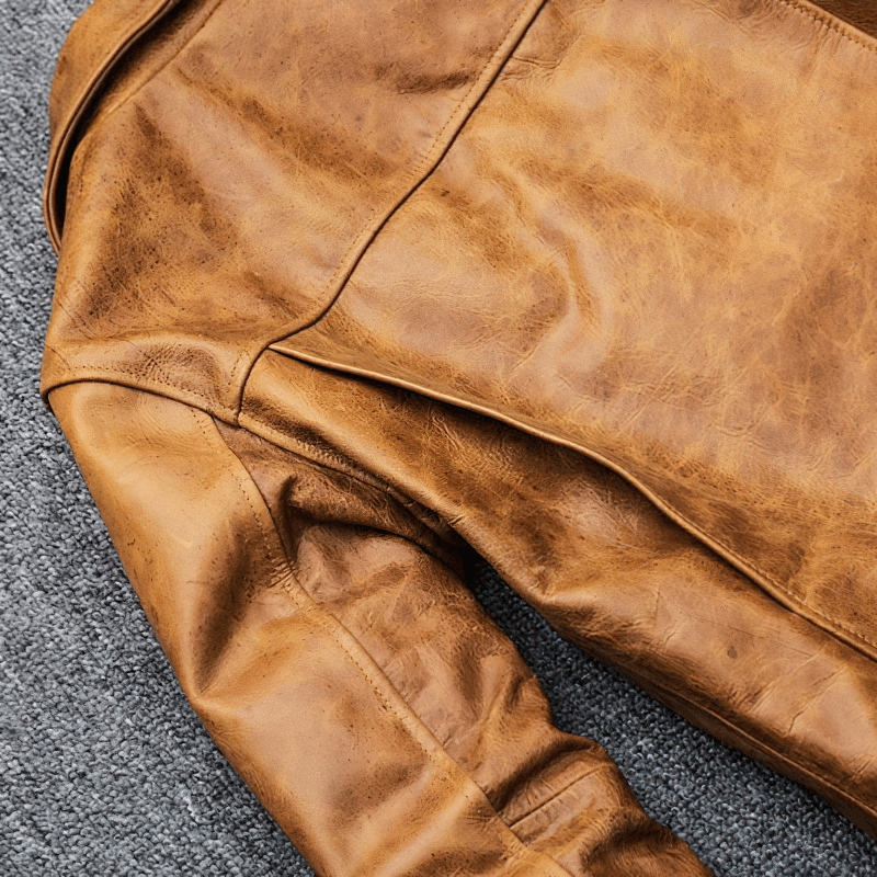 Close-up of men's yellow brown genuine leather motorcycle jacket showcasing its retro design and texture.
