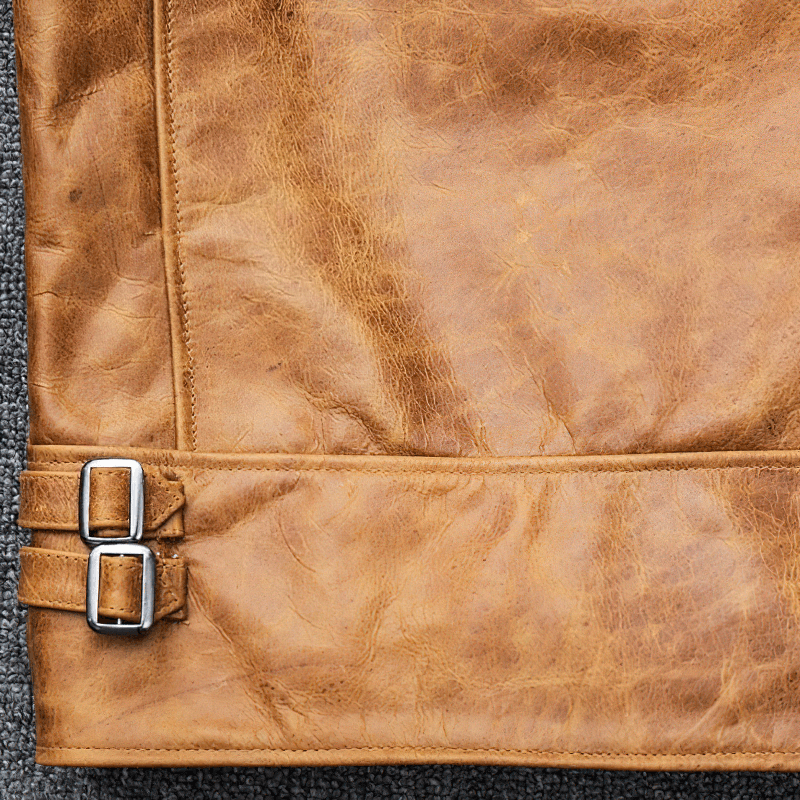 Close-up of the durable yellow brown leather with silver buckles on a men's motorcycle jacket.