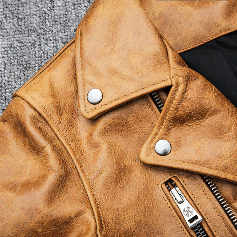 Close-up of yellow-brown men's leather motorcycle jacket showcasing turn collar and silver zipper.