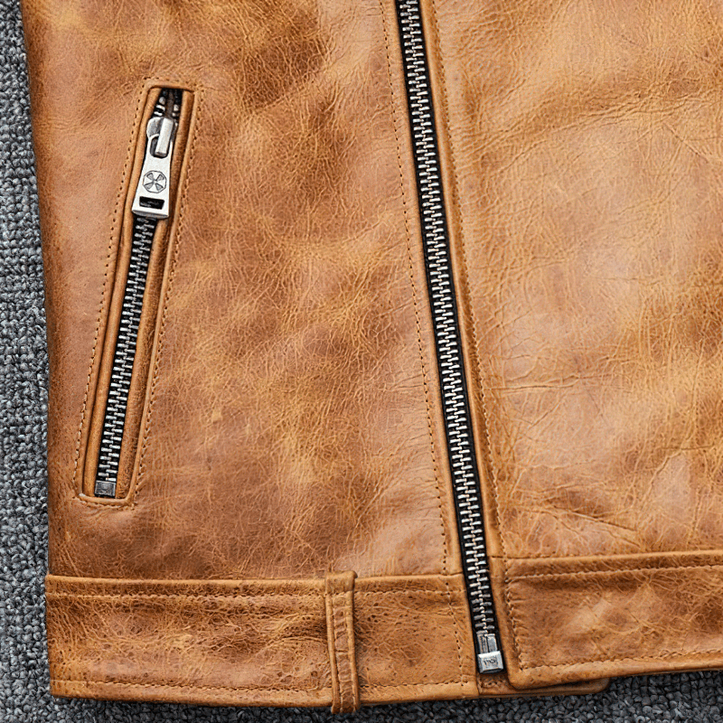 Close-up of men's genuine leather motorcycle jacket in yellow-brown with stylish silver zippers and retro design.