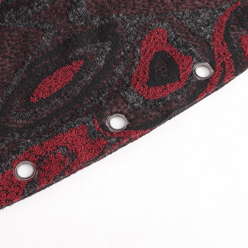 Close-up of men's goth coat fabric with intricate red and black patterns, featuring metal eyelets for unique style.