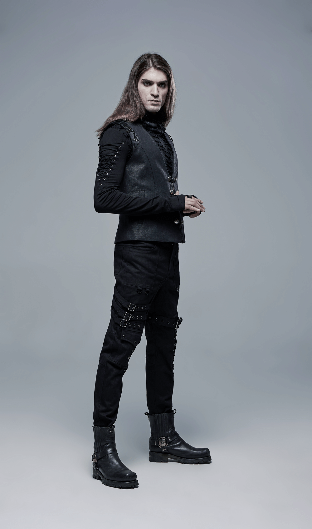 Men's gothic cargo pants with buckles and lace-up detail, styled with a sleek black vest and boots.
