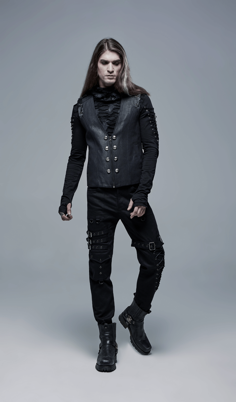 Model wearing black gothic cargo pants with buckles and a stylish vest, showcasing a punk-inspired look.