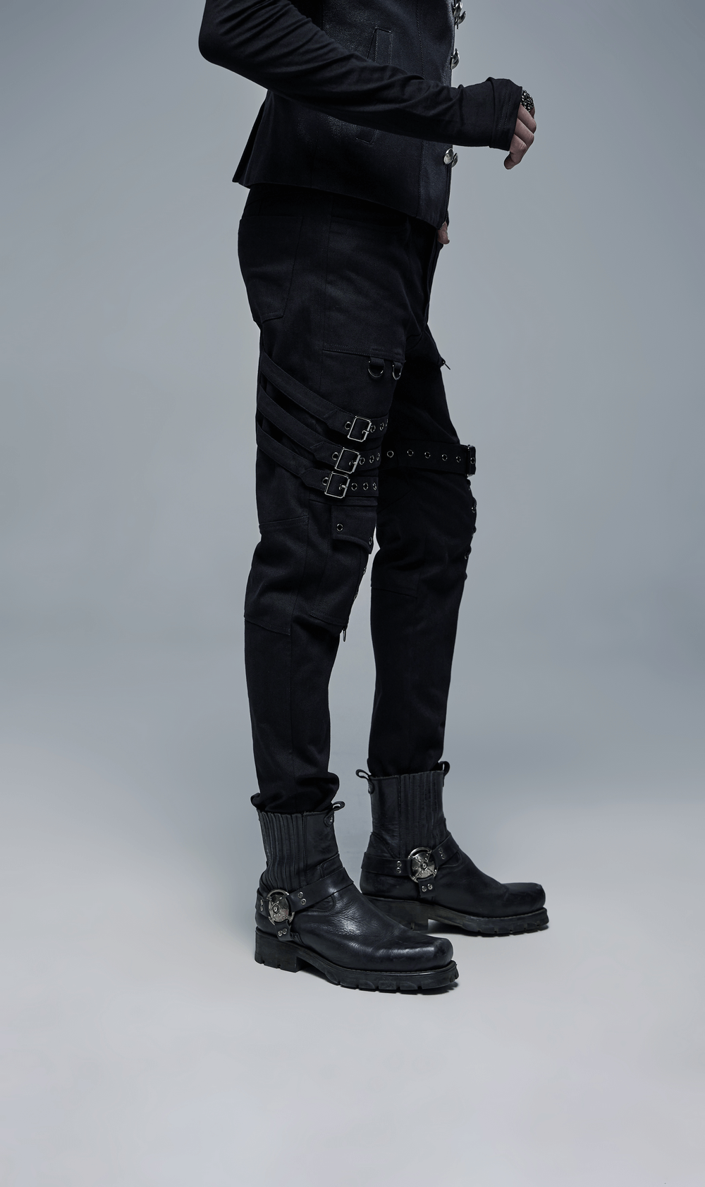 Men's black gothic cargo pants with buckles and lace-up detail, paired with stylish black boots.