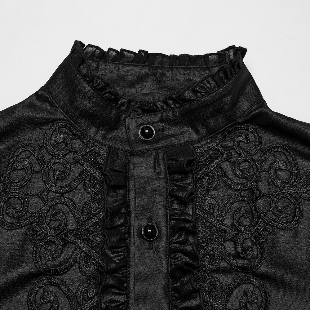 Close-up of men's gothic chiffon shirt featuring ruffles, lace decals, and black gemstone buttons on a black background.