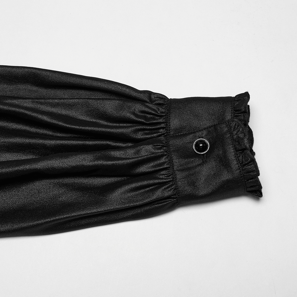 Close-up of the cuff of a men's gothic chiffon shirt featuring ruffles and a gemstone button.