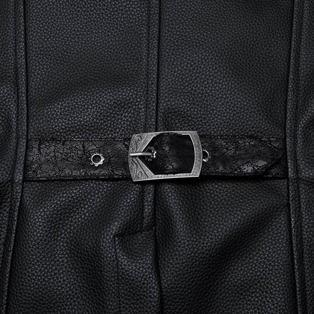 Close-up of a decorative metal buckle on a black faux leather vest with intricate texture and Gothic design.