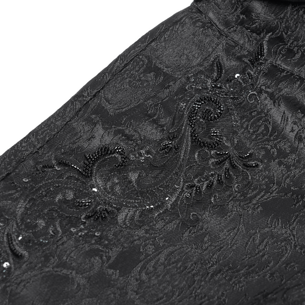 Close-up of ornate black jacquard fabric with intricate brocade pattern and shimmering details for gothic pants.